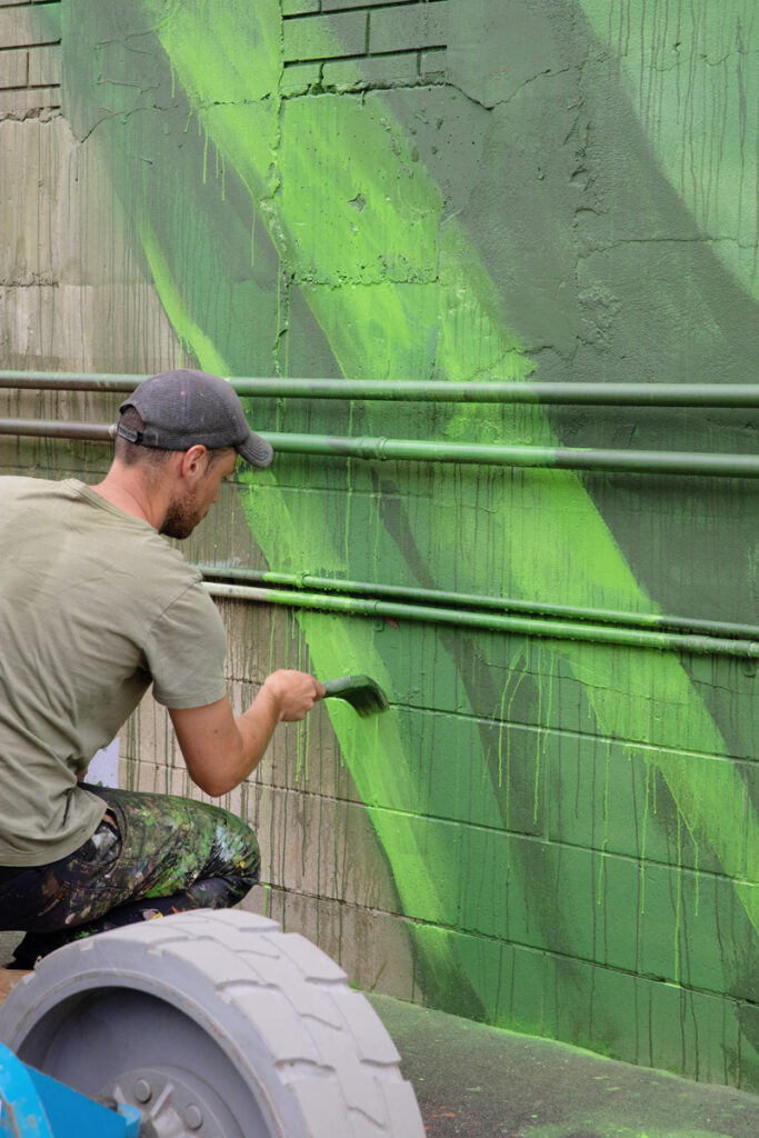 Cam Scale Mural Progress mural artist, Cam Scale adding detail to a large scale mural at the Burleigh Brewing Taphouse